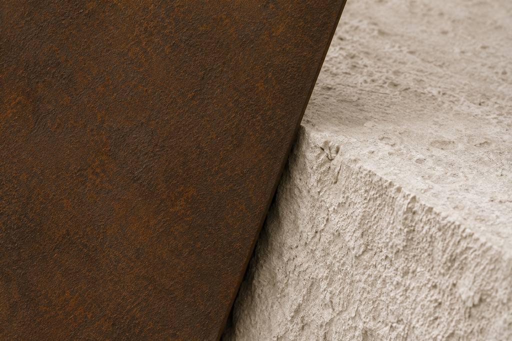 Vue macro Silent Quarry: des blocs de pierre calcaire fracturée soutenus par une structure en acier patiné.