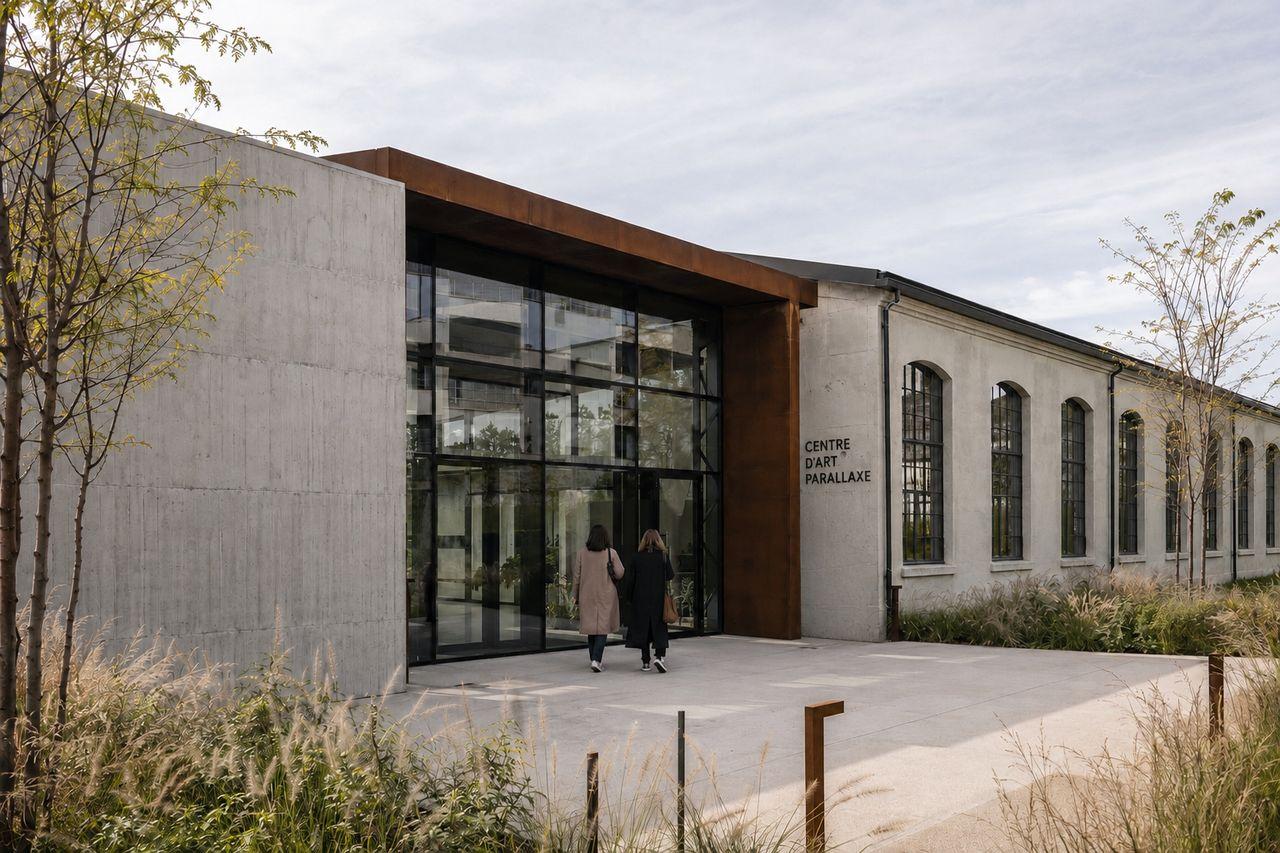 Vue principale de la façade du Centre d’Art Parallaxe, associant béton clair, verrière et structure en acier patiné.