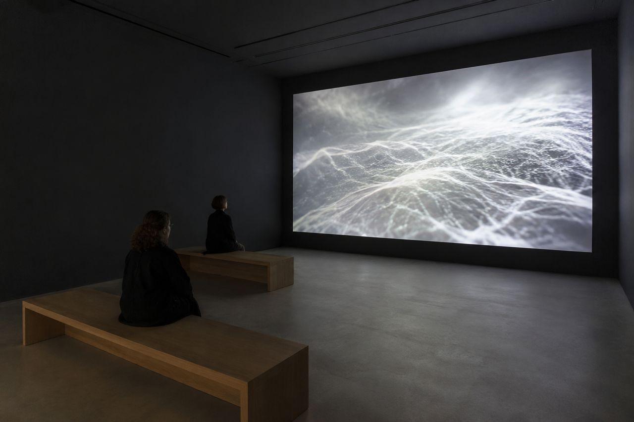 Salle immersive sombre conçue pour les projections, la lumière et les œuvres sonores.
